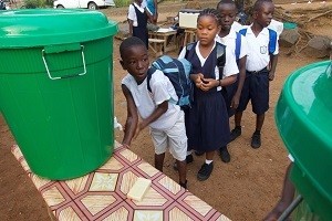 A boy washes his hands while other children queue behind him at the Slipway primary school in central Monrovia, the capital. On 18 March 2015 in Liberia, UNICEF has worked closely with the Government and local communities to develop safety protocols aimed at minimizing the risk of Ebola virus disease (EVD) infection as children have returned to learning. Schools across the country reopened on 16 Feuary, following a six-month closure because of the crisis. Teachers have been trained to implement and monitor safety measures, including taking childrens temperatures when they arrive to school and making them wash their hands before entering the classroom. Soap and other hygiene materials have been distributed, and mass mobilization campaigns on EVD prevention have been conducted nationwide.