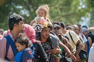 On 27 August, a group of children and adults stand at a reception centre waiting to be registered for a temporary transit visa at a reception centre near the town of Gevgelija in the former Yugoslav Republic of Macedonia after crossing the border from Idomeni in Greece. In late August 2015 in the former Yugoslav Republic of Macedonia, more than 52,000 people have been registered at the border by police in the town of Gevgelija, after entering from Greece, since June 2015. Since July 2015, the rate of refugees and migrants transiting through the country has increased to approximately 2,000 to 3000 people per day. Women and children now account for nearly one third of arrivals. An estimated 12 per cent of the women are pregnant. Many are escaping conflict and insecurity in their home countries of Afghanistan, Iraq, Pakistan and the Syrian Arab Republic. There are children of all ages traveling with their families. Some are unaccompanied minors aged 1618 years who are traveling in groups with friends. They are arriving in the country from Greece, transiting to Serbia and further to Hungary, from where they generally aim to reach other countries in the European Union.