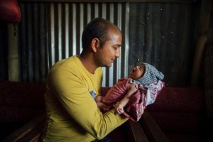 On 26 May, Narayan Krishna Shivakoti holds his crying 22-day-old son, Nirman, in a building in the earthquake-affected town of Singati, near the town of Charikot in Dolakha District, epicentre of the 12 May earthquake. Nirman was born in the period between the first and second earthquakes. Someday, when we look back, we won't remember this as a time of loss or earthquakes, but as when our first baby was born. And he is a healthy baby,