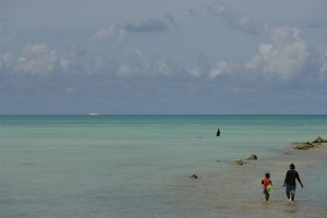 A boy and his father walk with their fishing gear into the Pacific Ocean near Tarawa, the capital.  In late 2006 in the Republic of Kiribati, childrens quality of life is declining, as it is across the region. Kiribati is one of 14 Pacific Island Countries, which form a group of atolls dispersed over 30 million square kilometres of the Pacific Ocean. Because populations are scattered across multiple islands, efficient delivery of health care, education and other social services is difficult. The region is also vulnerable to natural disasters like floods, typhoons and volcanic eruptions. While overall infant and under-five mortality rates have declined since 1990, some countries, including Kiribati, lag behind in improving child health and access to basic services. Across the region, birth registration systems are weak or fragmented. Sixty per cent of Pacific children are anaemic, and deficiencies in Vitamin A, iodine and other micronutrients are common. Immunization rates are declining in many nations, partly due to the challenge of maintaining the cold chain in remote islands. Some 20 per cent of Pacific Islanders have no access to improved drinking water, while 30 per cent lack sanitation facilities. Poverty forces many children to drop out of school, and while HIV/AIDS infection rates are low, unsafe sex practices and lack of knowledge prevail. Increases in teen pregnancies, drug and alcohol abuse, domestic and sexual violence and child trafficking are contributing to an overall decline in living standards for children and women. UNICEF and its partners are working with health ministries to improve birth registration practices and other child health initiates; deliver psychosocial support to children and families affected by natural disasters and political conflicts; and raise awareness among young people of HIV/AIDS and its prevention. UNICEF is also providing assistance throughout the region in the areas of immunization; child and maternal health; water and sanitation; and education.