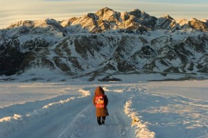 A first-grade student walks several kilometres to her home after school in the district of Altai, in Khovd Province. A mountain range rises in front of her.  In March 2010 in western Mongolia, heavy snow, strong winds and extreme cold have created crisis conditions in over half the countrys provinces. Temperatures have fallen to minus-50 degrees Celsius, and snow is impeding access to food, fuel, sanitation and basic medical care. The crisis, known locally as a dzud, has killed at least nine children in one province, and has trapped many others in dormitories with failing heating systems and limited food supplies. Over 22,000 children in dormitories need emergency aid, and an additional 40,000 children may soon need assistance as well. The Government has declared a state of disaster in 12 of the countrys 21 provinces, with seven additional provinces expected to fall into disaster status. The dzud poses longer-term threats as well: Cold temperatures have killed over 2.7 million livestock, which may increase unemployment and poverty for the third of the population employed in agriculture. Animal carcasses also threaten to pollute soil and spread disease when the cold weather recedes in June. UNICEF is responding by providing food, fuel, blankets, hygiene kits, medical supplies and boots to over 60,000 children, including those in dormitories and isolated villages. UNICEF is also collaborating with other United Nations agencies to supply hospitals and provide mobile medical teams in isolated areas. The United Nations Development Programme (UNDP) is offering a cash-for-work programme that pays herders to properly dispose of livestock carcasses.