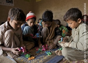 Ten-year-old Khairzada Zaman (right) and other boys play with blocks in a UNICEF-supported child protection centre in Ghaniabad Village of Dera Ismail Khan District, Khyber-Pakhtunkhwa Province. Khairzada wears a cloth bandage over his oken hand. I was home when water came, he said about the floods. It was about 4 p.m. We had to leave immediately, leaving everything behind Water destroyed everything, even my textbooks. My school uniform is rotten. Later, when we came back, there was a lot of mud around. I slipped and oke my hand. Khairzada now lives in a tent with his parents and seven siblings. By the end of January 2011, the people of Pakistan continue to struggle with the effects of the worst flooding in their countrys recorded history. The flooding began in mid-July 2010 and, at its height, affected 20 million people, half of them children. An estimated 170,000 people remain displaced in camps and spontaneous settlements, primarily in Sindh Province, but all four provinces and the Federally Administered Tribal Areas face difficult recoveries. Millions have returned to ruined homes and damaged infrastructure, with recovery and rebuilding costs estimated at US$8-10 billion. Six months after the crisis began, a joint nutrition survey conducted by the Government and aid agencies, including UNICEF, has revealed that malnutrition rates for children under five far exceed critical levels: the rate of severe acute malnutrition, a deadly condition, stands at 6.1 per cent in northern Sindh, and the provinces global acute malnutrition rates are between 21 and 23 per cent. Forty per cent of households lost entire food stocks, and over 2 million hectares of crops were destroyed, leaving over 5.7 million people food insecure. In Khyber-Pakhtunkhwa Province, 650,000 people are displaced by civil conflict and unable to return due to winter conditions. They are further threatened by landmines that have been moved by floodwaters. From the start, UNICEF has joined the government, other UN agencies and partner NGOs in responding to this unprecedented emergency. UNICEF is supporting: the supply of drinking water to 3.5 million people daily, and sanitation facilities to more 1.9 million; the provision of services for 120,000 malnourished children and women in feeding centres; the immunization of 9 million children against measles and polio; and the creation of temporary learning centres for 180,000 children, and child-friendly centres for 200,000 children. UNICEF has appealed for US$251 million to fund its emergency response, of which US$198 million has been received or pledged  leaving a US$52 million gap still needed to meet vital child rights concerns.