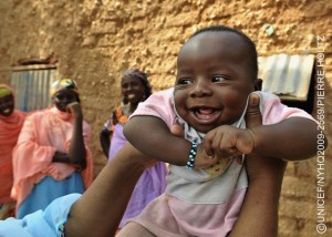 Three-month-old Abdoulrachid Hamissou smiles in the village of Foura Guiké, in the southern Maradi Region. Abdoulrachid has benefitted from the promotion of essential family practices in the village. Four volunteers in the community promote essential family practices that reduce child diarrhoea, prevent malaria and improve hygiene. They also promote exclusive eastfeeding and growth monitoring for children, practices that help prevent malnutrition. In October 2009 in Niger, rates of malnutrition are escalating due to irregular rains and faltering crop yields. The country already has high chronic malnutrition rates, with half of children experiencing stunted growth, and one of the highest child mortality rates in the world, with 17 per cent of children dying before the age of five. Late and erratic rains led to failed harvests in the southern regions, where farmers and pastoralists were already contending with reduced pasture lands and high food prices. Meanwhile, heavy rains caused the worst flooding in decades in the northern Agadez Region, destroying farms and wiping out crops. The flood damage in Agadez leaves little food or employment for southern migrants who travel north to work the fields each year. According to the Government, over 100 agricultural zones, and nearly two million people, are food insecure, numbers that may rise. In response, UNICEF, the World Food Programme (WFP), Médecins sans frontières (MSF) and other partners are providing health care and nutritional support throughout the country. Food distributions have also been launched in the southern regions to limit rising malnutrition rates.