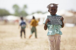 A girl holds a slate after leaving school as she stands in the Toukra IDP site in N'Djamena, Chad on Monday October 22, 2012. UNICEF UK - local copies saved here: Y:Key-initiativesIFSahel-Stories-2012Chadphotos only_W