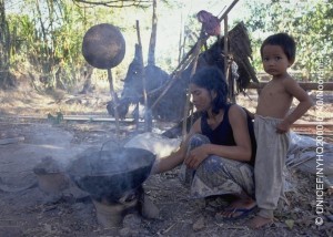 Accompanied by a toddler, a woman stokes a cooking fire in a village in the south-eastern province of Svay Rieng. In 2000 in Cambodia, after more than a decade of intermittent peace, the country is continuing its recovery from 30 years of conflict, including genocide. Despite progress in health and nutrition, maternal and infant mortality rates are the highest in south-east Asia, most of the predominantly rural population still lacks access to essential services, and problems of ongoing violence, displacement and landmines continue to take their toll. HIV/AIDS is spreading rapidly, accelerated by a growing commercial sex industry, with an estimated 35 per cent of sex workers under 18 years of age, almost half of whom are presumed to be HIV positive. With half of the country's population under 18 years of age, these indicators represent a major threat to their future, including increased rates of mother-to-child transmission. UNICEF programmes to help combat the spread of HIV/AIDS include support for prevention and awareness programmes to all social sectors, including student-to-student education exchanges, the provision of testing and counselling services, and improved access to recovery and care for affected children and families.