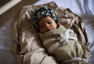 A new born baby from a displaced family lies on a bed at the Mardan Medical Complex, where displaced pregnant women living in camps and communities are referred for delivery./More than 2.5 million people have been displaced since fighting began in PakistanÕs North West Frontier Province in August 2008. More than half of those displaced are children and need urgent humanitarian assistance. About 200,000 live in refugee camps and the rest in host communities. According to the United Nations Population Fund (UNFPA) out of the 6,000 displaced pregnant women some 4,300 are due to give birth in June. To tackle the lack of enough medics available and of emergency obstetric and neonatal care in the camps, UNICEF is supporting the establishment of four Maternal and Child Health Units in different camps.