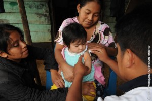 (Centre) Irma Irene Yat Chú, an indigenous Mayan woman, holds her 1-year-old daughter, Lisbeth Gaiela, at home in the community of Chivencorral in Cobán Municipality, in Alta Verapaz Department. Volunteer health workers from a community health centre, (left-right) Laura de Jesús Icoó Pop and Mario Cucul, prepare a measles vaccine for Lisbeth. The centre, run by the Ministry of Health with support from UNICEF, serves a population of 3,476 and is open twice a week. Through home visits, volunteer health workers provide routine health care and immunizations for pregnant women and children under age 5 who are unable to travel to the health centre. [#6 IN SEQUENCE OF EIGHT]  In November 2012 in Guatemala, the Government and other partners are continuing to assure sustained routine immunization of children  now reaching 92 per cent of all infants  against a range of vaccine-preventable diseases. The countrys last endemic case of measles was in 1997. In the entire Americas Region (covering North, Central and South America), the last endemic measles case was in 2002 and the last endemic case of rubella was in 2009  part of global efforts to eradicate these diseases. Worldwide, measles remains a leading cause of death among young children: In 2010, an estimated 139,300 people  mainly children under the age of 5  died from the disease. Nevertheless, these deaths decreased by 71 per cent from 2001 to 2011, thanks in part to the Measles & Rubella Initiative, a global partnership led by the American Red Cross, the United Nations Foundation, the United States Centers for Disease Control and Prevention (CDC), WHO and UNICEF. In Guatemala, despite this success, significant other challenges for children remain, much of it related to poverty levels that affect more than half of all children and adolescents. Poverty also contributes to chronic malnutrition affecting half of all under-5 children (with higher rates among indigenous populations); an average national education level of under six years of primary school (under three years for the rural poor); and high, though decreasing, rates of violence. Guatemala is also one of the worlds most vulnerable countries to climate change, suffering a major climate-related emergency every year since 2008. On the positive side, birth registration is improving, with more than 95 per cent of newborns now being registered. UNICEF is working with the Government and other partners to sustain achievements in health, address the high levels of malnutrition, strengthen responses to crimes against children and increase protection services for children throughout public services.