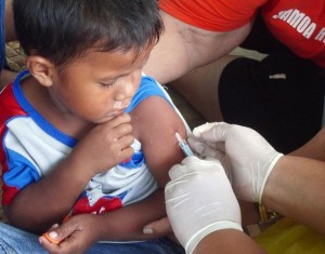 A boy receives a measles vaccination at a temporary clinic in Lalomanu, a village on the eastern coast of Upolu, one of Samoas two main islands. The measles vaccination campaign aims to reach 32,000 children, between the ages of six months and five years, throughout the country. UNICEF is providing essential equipment for the campaign, including vaccines, Vitamin A, syringes and cold-chain equipment. The World Health Organization is providing technical and logistical support.  In October 2009 in Samoa, some 3,200 people remain displaced by a tsunami that killed over 140 people on 29 September. The tsunami was triggered by an 8.3-magnitude earthquake on the ocean floor approximately 190 kilometres from Apia, the capital. Coastal villages on Upolu, one of the countrys two main islands, and the small islet of Manono experienced extensive damage. Schools and houses were destroyed, and 10 per cent of subsistence agricultural production was lost due to damaged livestock, gardens and equipment. The destruction leaves affected communities, most of which were already impoverished, increasingly vulnerable. Of the countrys 88,000 children, an estimated 9,000 are affected by the tsunami, including 2,000 who are displaced. Many of the displaced are living in inland camps, where they face increased risk of disease outeaks. The displacement has exacerbated existing problems with water safety; even under normal circumstances, 12 per cent of the countrys 187,000 people lack access to an improved water source. UNICEF is responding by providing safe drinking water, rehydration salts, soap, hygiene kits, vaccines and other essential supplies to the displaced.