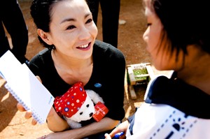 UNICEF Goodwill Ambassador Maggie Cheung gives a teddy bear and notebook to a girl who is HIV-positive, in Ruili City, Yunnan Province. The teddy bear and notebook display the UNICEF logo. In April 2010 in China, acclaimed international actress and newly appointed UNICEF Goodwill Ambassador (China) Maggie Cheung visited children and women affected by HIV/AIDS in Ruili City, in the south-western province of Yunnan. Although China has relatively low rates of HIV infection, the risk of transmission is significantly higher in parts of Yunnan Province, which borders major opium producing regions in neighbouring countries. HIV prevalence is 0.1 per cent nationally, but rises to 20 per cent among intravenous drug users in Yunnan. The disease remains highly stigmatized and poorly understood by much of the population, factors that could accelerate the spread of the epidemic, particularly among the rural poor, migrants, sex workers and injecting drug users. On 29 April, Ms. Cheung was appointed a UNICEF Goodwill Ambassador to advocate on behalf of vulnerable children, including those affected by HIV/AIDS and disability. Her visit to Yunnan aimed to raise awareness of HIV/AIDS and to mitigate stigma associated with the disease. By the end of 2007, an estimated 700,000 Chinese were HIV-positive.