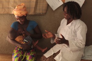 (Left-right) A woman learns how to correctly hold and eastfeed her child, with help from Nurse Pascaline Bandre, at Rapadama Traditional Health Centre in the village of Rapadama in Plateau-Central Region. In partnership with the NGO Association Chant de Femmes (ACF), UNICEF supports the work of community health workers, who discuss issues related to health and nutrition with local communities. When Nurse Bandre arrived at the centre four years ago, 10 to 15 malnourished children were ought in each week. 