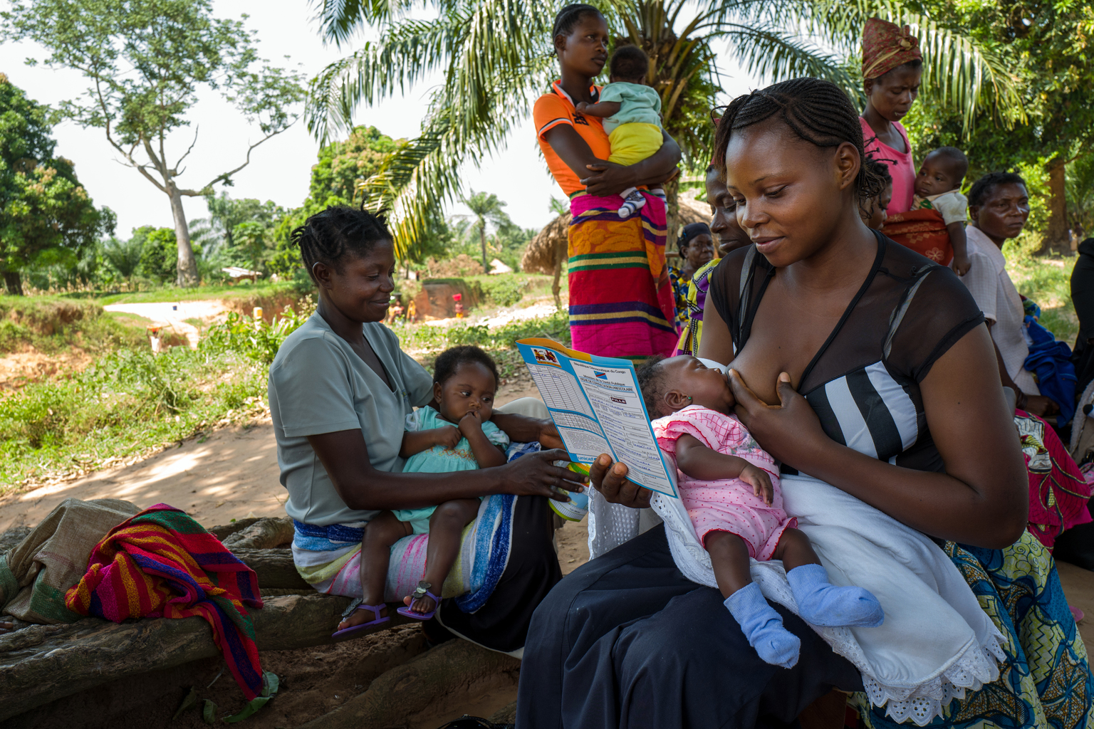 Le 20 mai 2017, une femme lit le carnet de santé de son enfant lors d'une session de vaccination de routine dans un quartier de Kabea Kamwanga, une petite ville située à 70 km au nord-ouest de Mbuji-mayi, en direction de Kananga, dans la province du Kasaï Orientale, au sud de la République démocratique du Congo, une région en proie aux conflits entre les miliciens du chef traditionnel Kamuina Nsapu et les Forces Armées de la République démocratique du Congo (FARDC) depuis juin 2016. / On May 20th, 2017, a woman is reading the health record of her child during a routine immunization session in a neighborhood of Kabea Kamwanga, a small town located 70 km north-west of Mbuji-mayi, in the direction of Kananga, in the province of Kasai Orientale, in the south Of the Democratic Republic of the Congo, a region plagued by conflict between the militia of the traditional leader Kamuina Nsapu and the Armed Forces of the Democratic Republic of the Congo (FARDC) since June 2016. In August 2016, fighting oke out in one of the Democratic Republic of Congos (DRC) poorest regions - Kasai - after a traditional leader was killed in clashes with security forces. The situation deteriorated in 2017, unleashing a wave of violence that has now engulfed nine of the countrys 26 provinces.