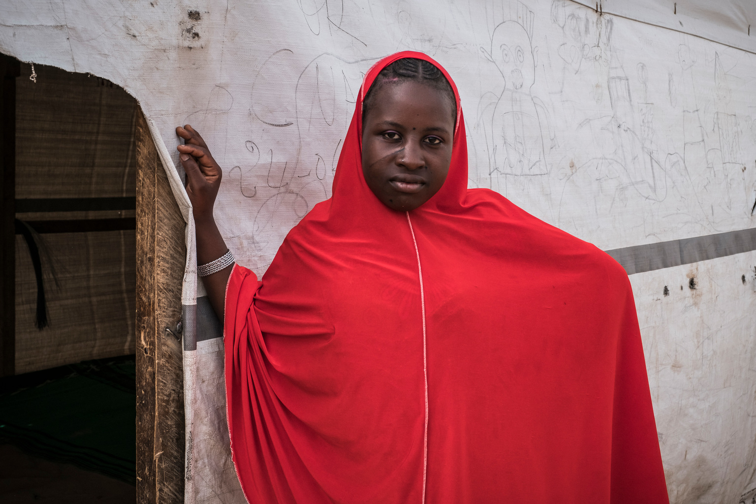 Nigerian refugee Hafsa Oumar, 16, stands outside a classroom at the Dar Naim school, in Daresalam refugee camp, Lake Region, Chad, Thursday 20 April 2017. Before coming to Chad, Hafsa never had a chance to attend school. Hafsa enrolled in school for the first time when she arrived in Chad in 2015. However, she stopped attending school following her marriage in Feuary 2017. More than 25 million children between 6 and 15 years old, or 22 per cent of children in that age group, are missing out on school in conflict zones across 22 countries. In response to the education crisis in Chad, UNICEF has since the start of 2017 provided school supplies to more than 58,000 students, distributed teaching materials to more than 760 teachers, and built 151 classrooms, 101 temporary learning spaces, 52 latrines and 7 sports fields. UNICEF Chad also supported the salaries of 327 teachers for the 2016-2017 school year. To help drive an increased understanding of the challenges children affected and uprooted by conflict face in accessing school, UNICEF advocate Muzoon Almellehan, a 19-year-old Syrian refugee and education activist, travelled to Chad, a country where nearly three times as many girls as boys of primary-age in conflict areas are missing out on education.