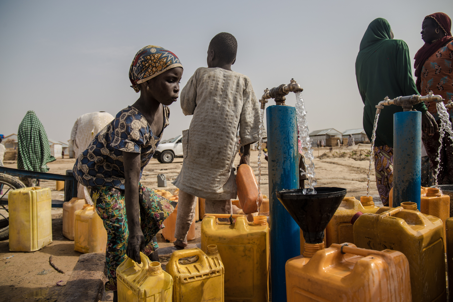 On 13 March 2017, Zara collects water for use at their home in Bakassi IDP camp, in Maiduguri, the capital of Borno State. Four solar powered boreholes with 10,00 litre overhead storage for each borehole and 60 water taps are servicing 21,000 Internally Displaced Persons from Gwoza, Marte, Monguno LGAs. The prolonged humanitarian crisis in the wake of the Boko Haram insurgency has had a devastating impact on food security and nutrition in northeast Nigeria, leading to famine-like conditions in some areas, according to a World Food Programme (WFP) situation report from late Feuary 2017. The United Nations Office for the Coordination of Humanitarian Affairs (OCHA) projects that by June 2017 some 5.1 million people in Nigeria will be food insecure at crisis and emergency levels. In 2017 in northeast Nigeria, in Borno, Adamawa and Yobe, the three states most directly affected by conflict, 75 per cent of water and sanitation infrastructure in conflict-affected areas has been damaged or destroyed, leaving 3.8 million people with no access to safe water. Displaced families are putting enormous pressure on already strained health and water systems in host communities. With the ongoing disruption to basic services the likelihood of waterborne diseases, such as diarrhoea and cholera, is growing and children are worst hit in such conditions leading to increase malnutrition and mortality. One third of the 700 health facilities in the hardest-hit state of Borno have been completely destroyed and a similar number are non-functional. As at 15 March 2017, over the past 12 months, UNICEF and partners have provided safe water to nearly 666,000 people and treated nearly 170,000 children suffering from severe acute malnutrition in the three conflict-affected northeast Nigerian states of Borno, Yobe and Adamawa. As part of cholera preparedness, UNICEF and other WASH Sector partners are building the capacity of government and NGOs on cholera response and developing contingency plan